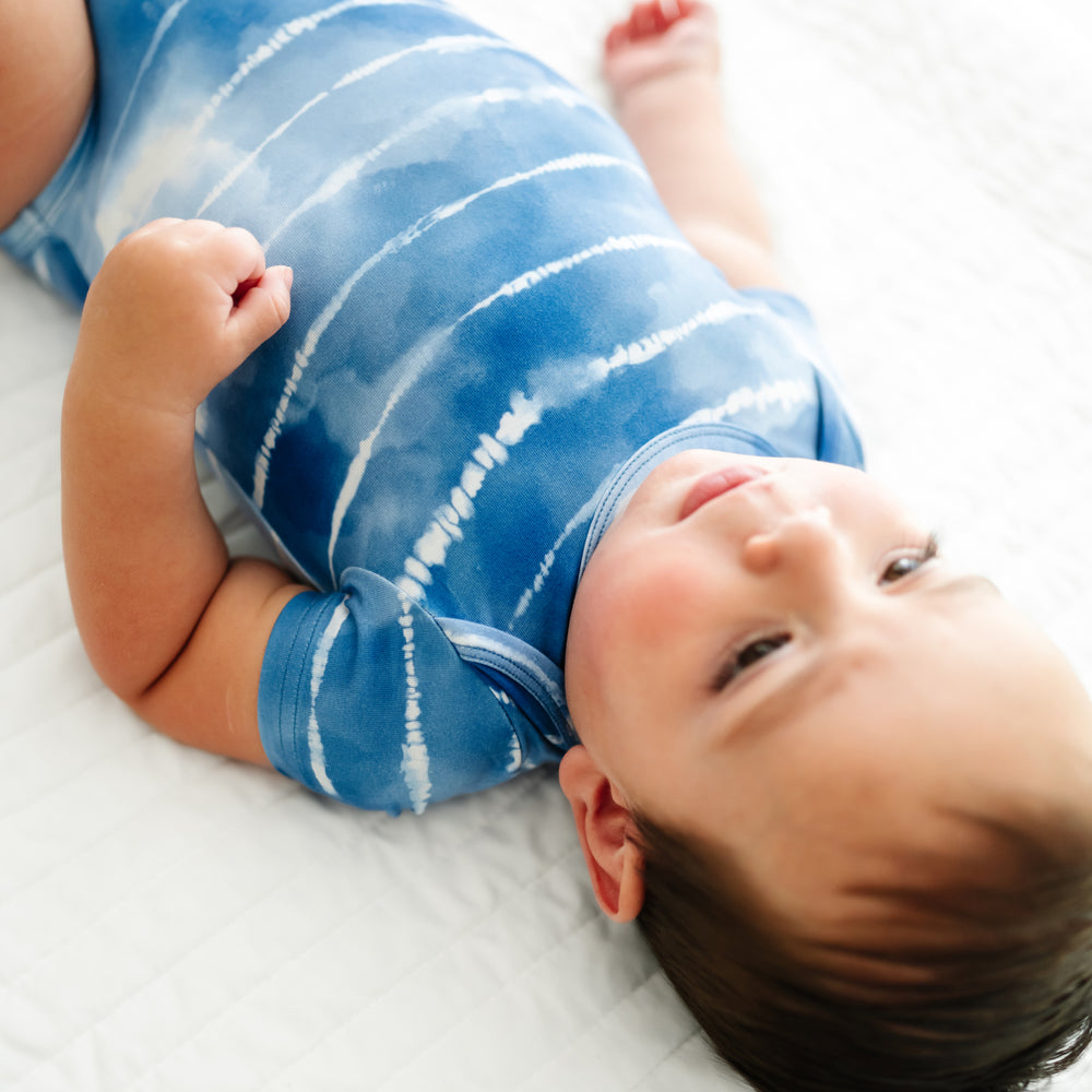 Close up image of a child wearing a Blue Tie Dye Dreams bodysuit