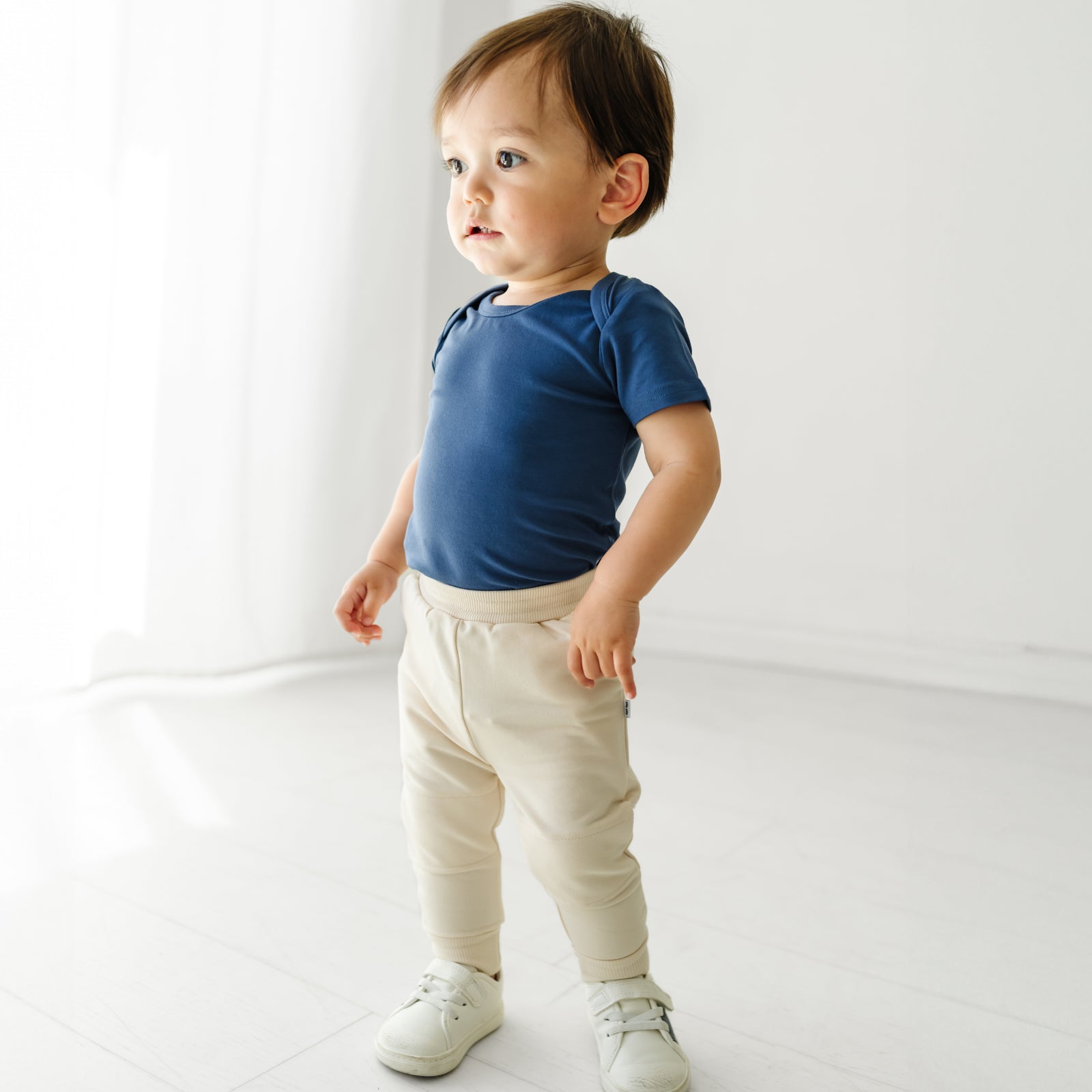 Child wearing a Vintage Navy bodysuit and coordinating Play joggers