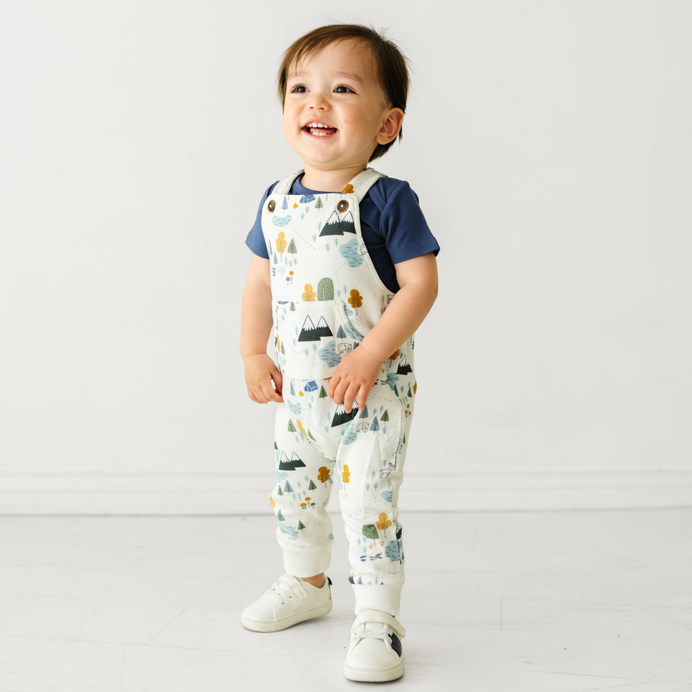 Child wearing Let's Explore overalls and coordinating Play bodysuit