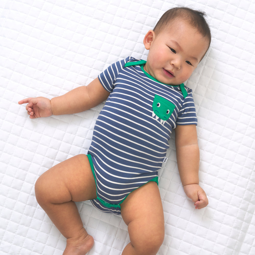 Child laying on a bed wearing a Vintage Stripes bodysuit