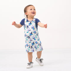 Child wearing a Seas the Day shorty overall paired with a Vintage Navy bodysuit