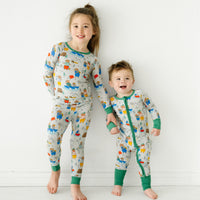 Two children holding hands wearing matching Papa Bear pajamas in two piece and zippy styles
