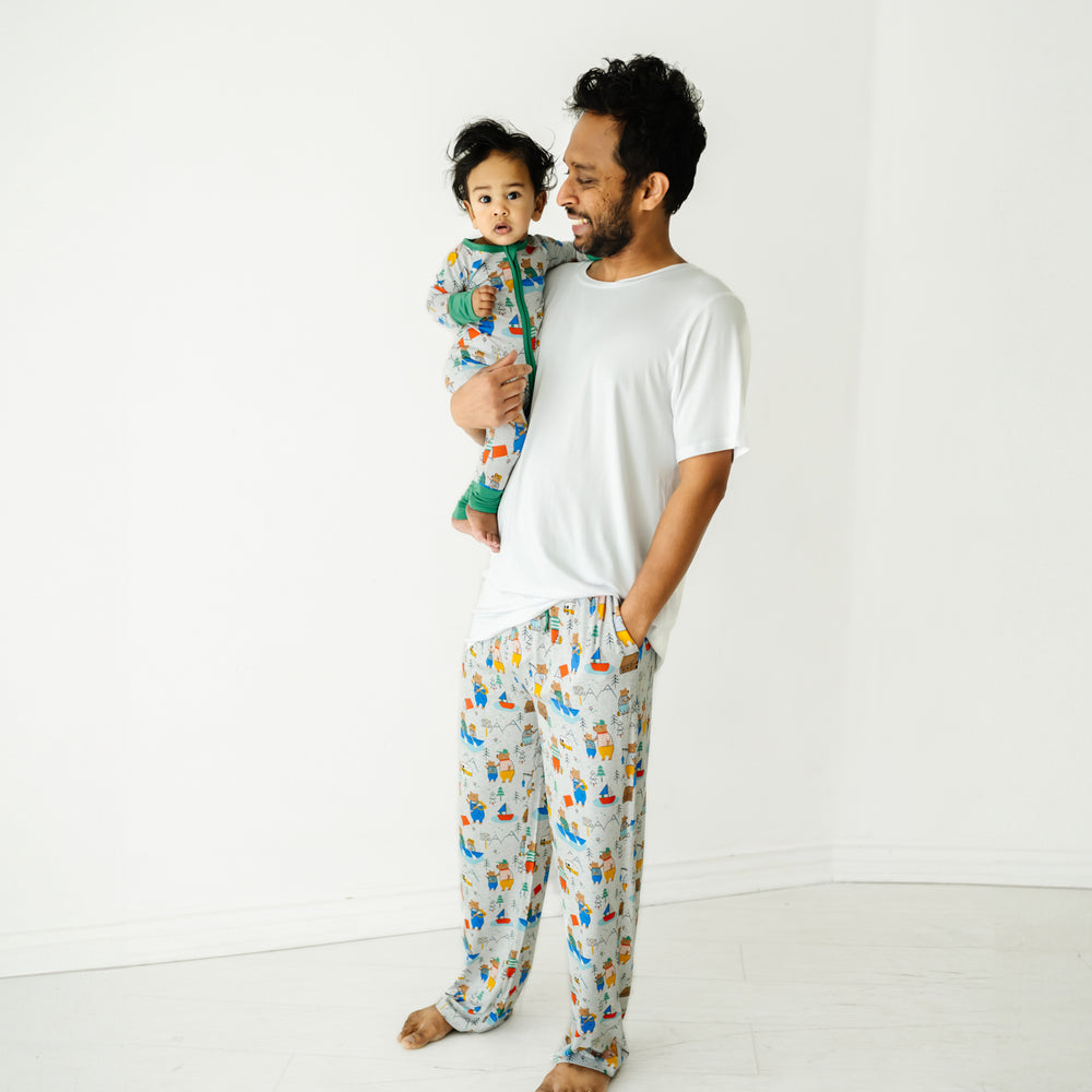 Dad holding his child wearing matching Papa Bear pajamas. Dad is wearing men's Papa Bear pajama pants and a men's Bright White pj top. Child is wearing a matching Papa Bear Zippy