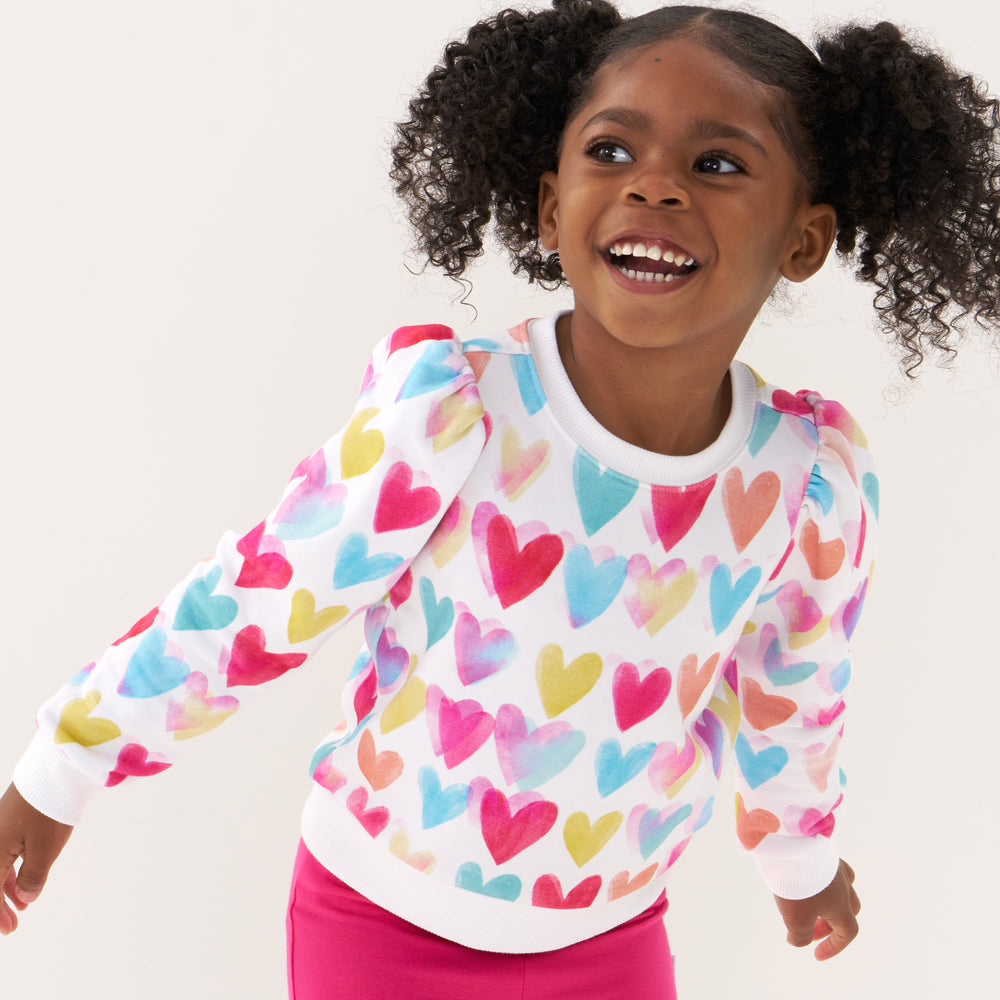 Click to see full screen - Close up image of a child wearing a Watercolor Love puff sleeve crewneck