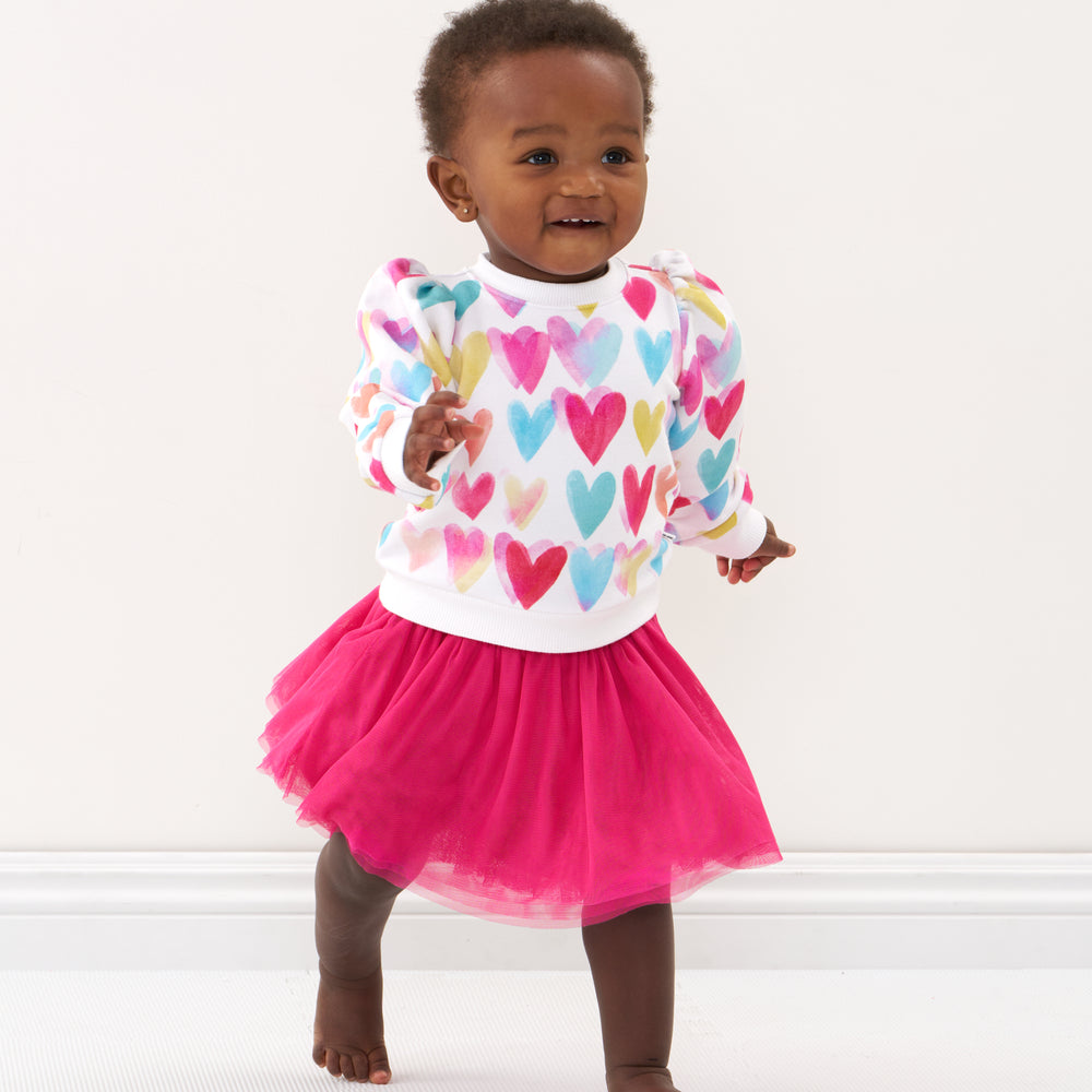 Click to see full screen - Child wearing a Watercolor Love puff sleeve crewneck and coordinating tutu skirt