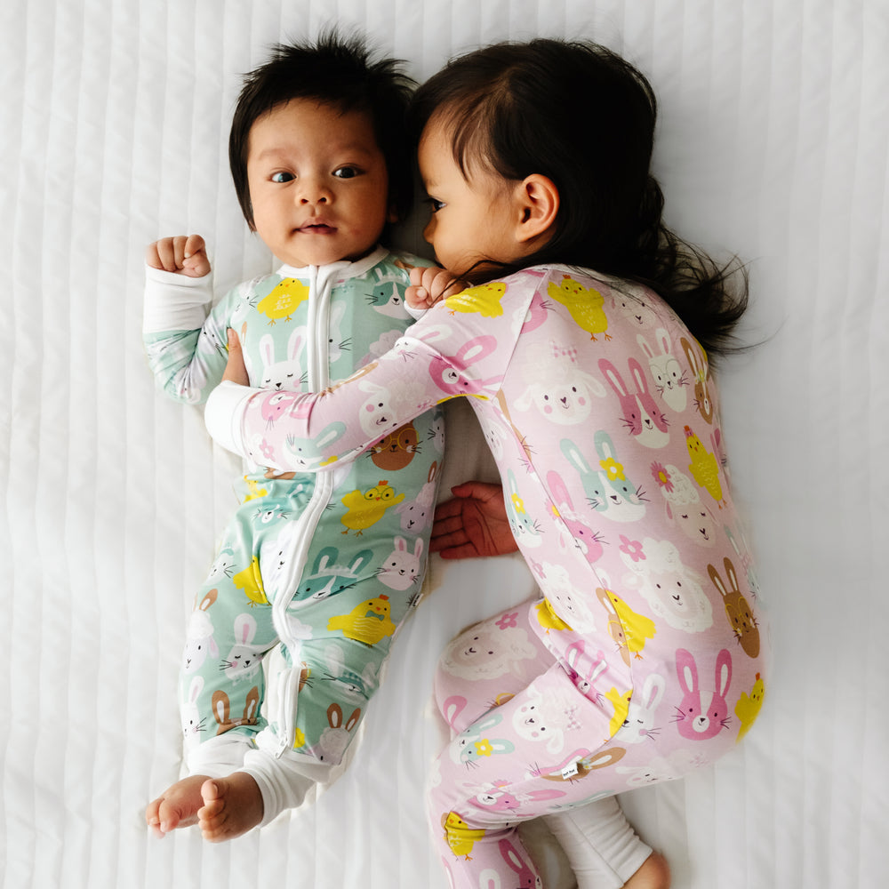Click to see full screen - Two children cuddling together wearing coordinating Pink and Aqua Pastel Parade zippies