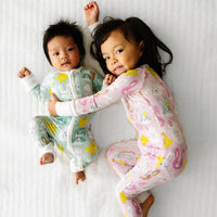 Two children cuddling together wearing coordinating Pink and Aqua Pastel Parade zippies
