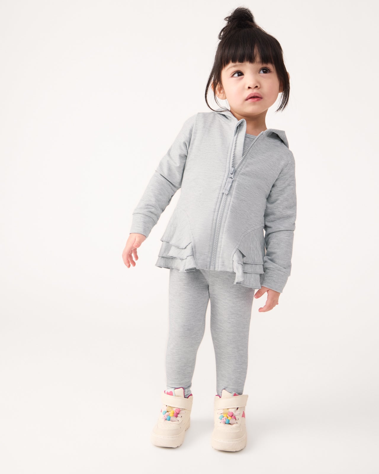 Standing girl wearing the Light Heather Gray Peplum Hoodie and Leggings