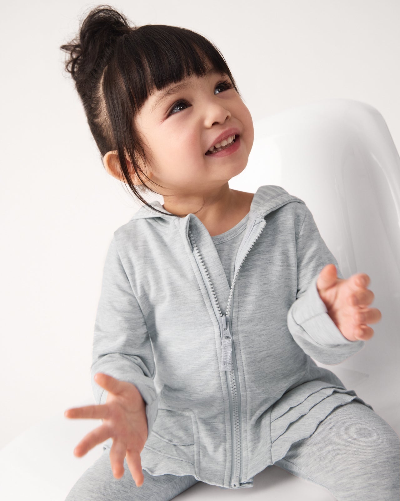 Clapping child wearing the Light Heather Gray Peplum Hoodie