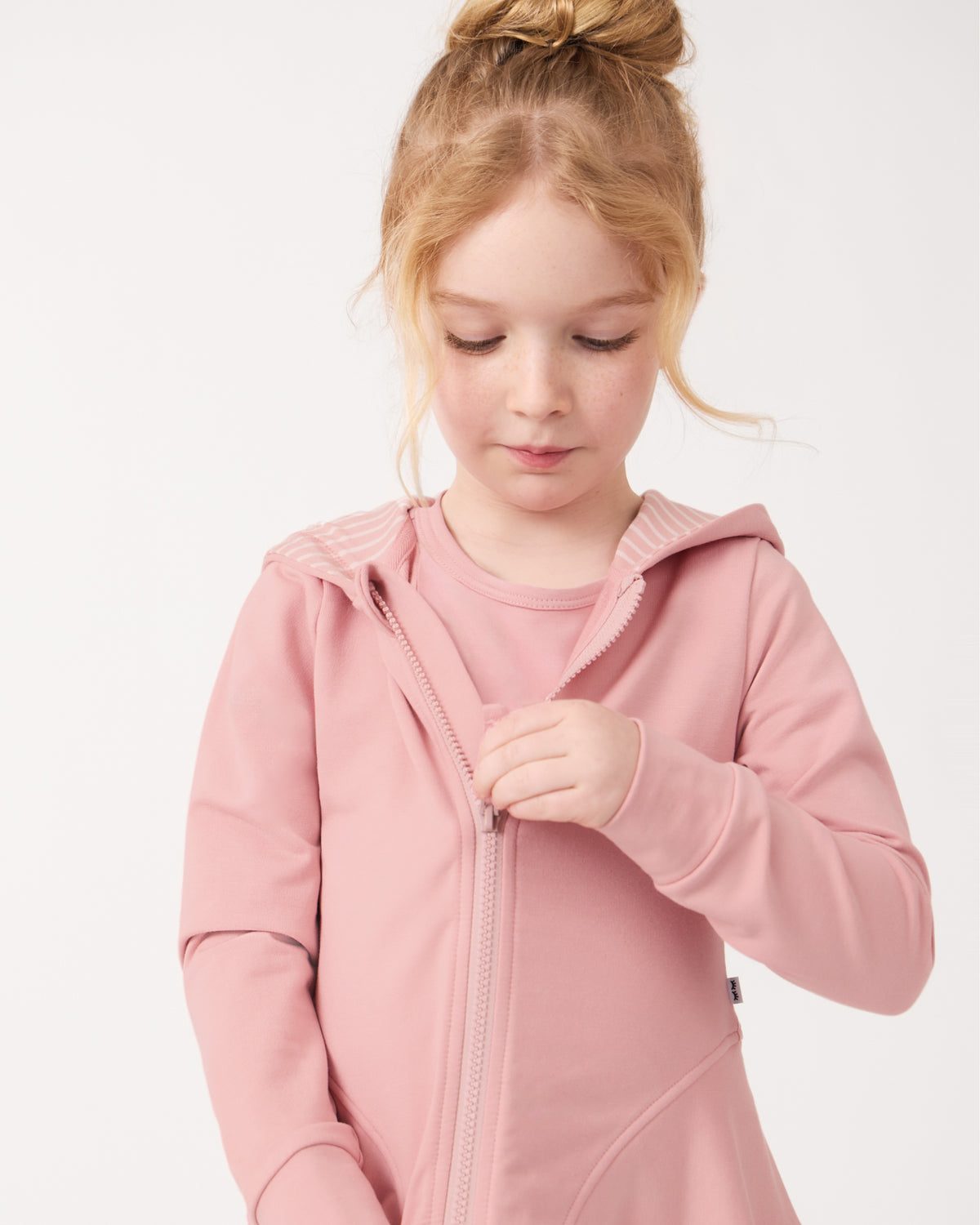 Girl zipping up the Mauve Blush Peplum Hoodie