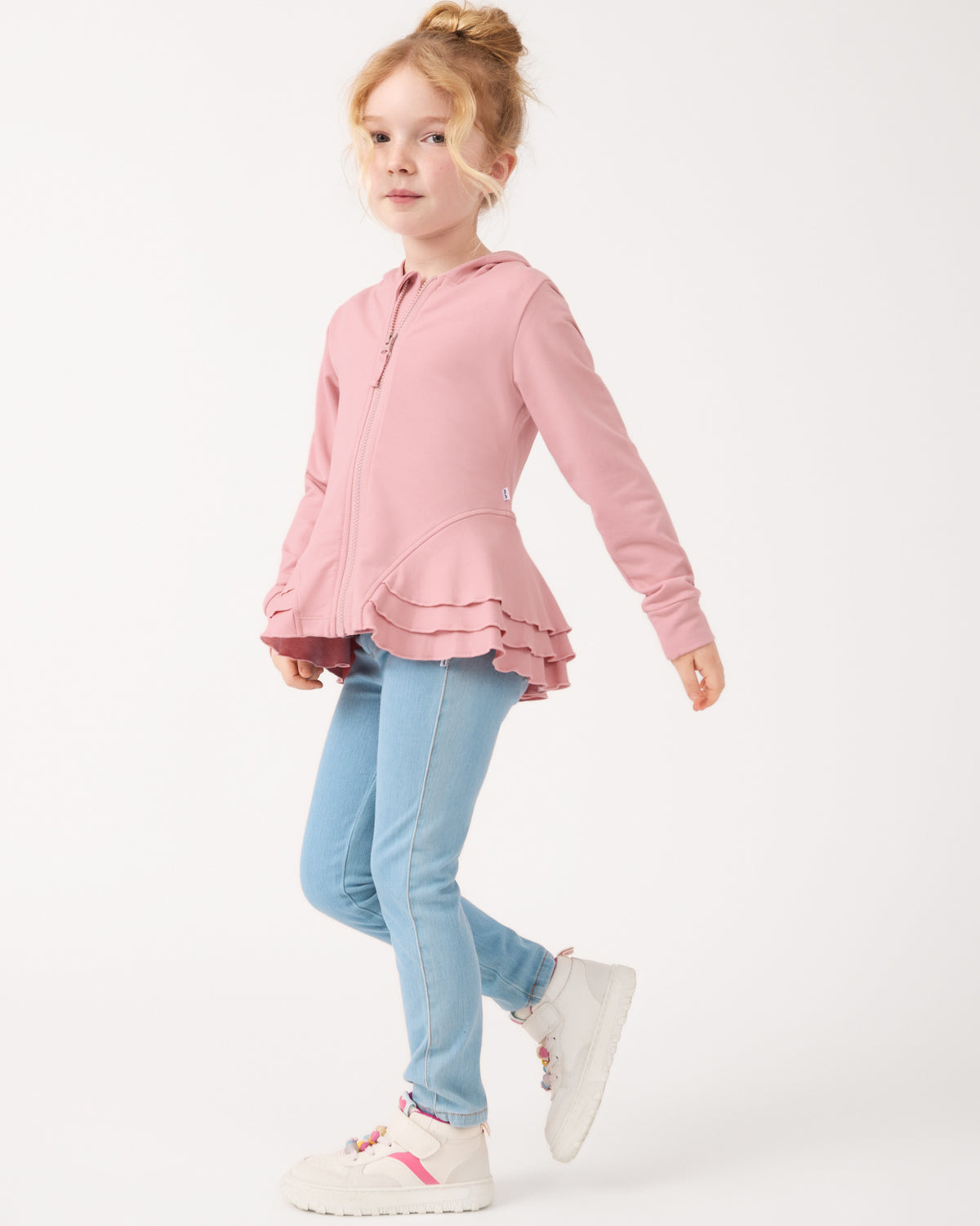 Girl wearing the Mauve Blush Peplum Hoodie with light wash jeggings