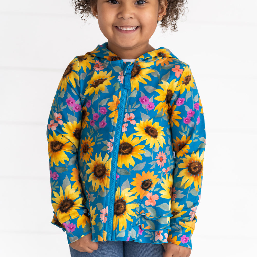 Close up image of a child wearing a Sunflower Fields Peplum Hoodie