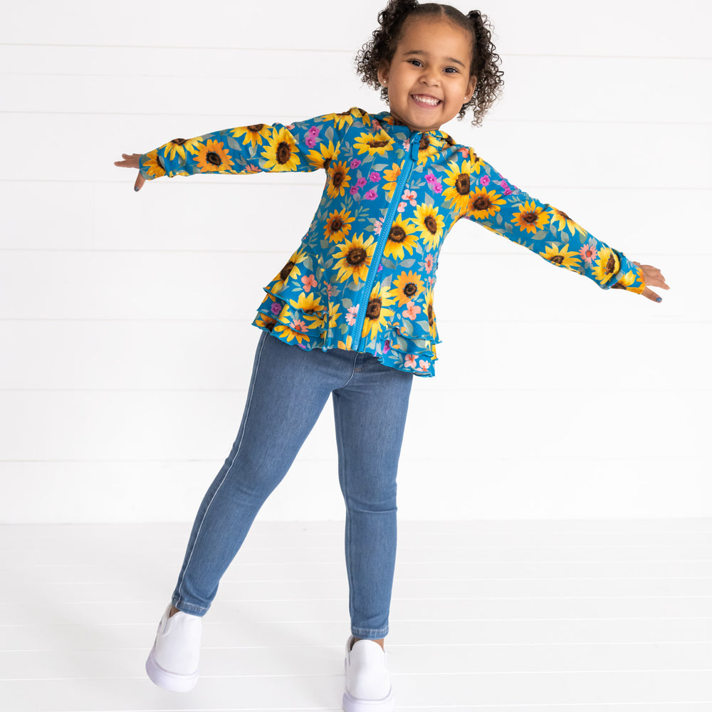 Image of a child wearing a Sunflower Fields Peplum Hoodie and Midwash Blue Denim Jegging