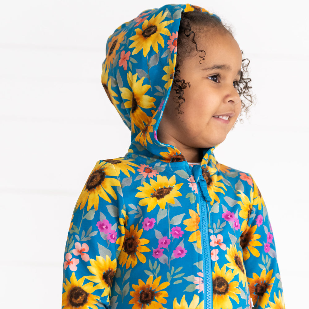 Close up image of a child wearing a Sunflower Fields Peplum Hoodie with the hood up