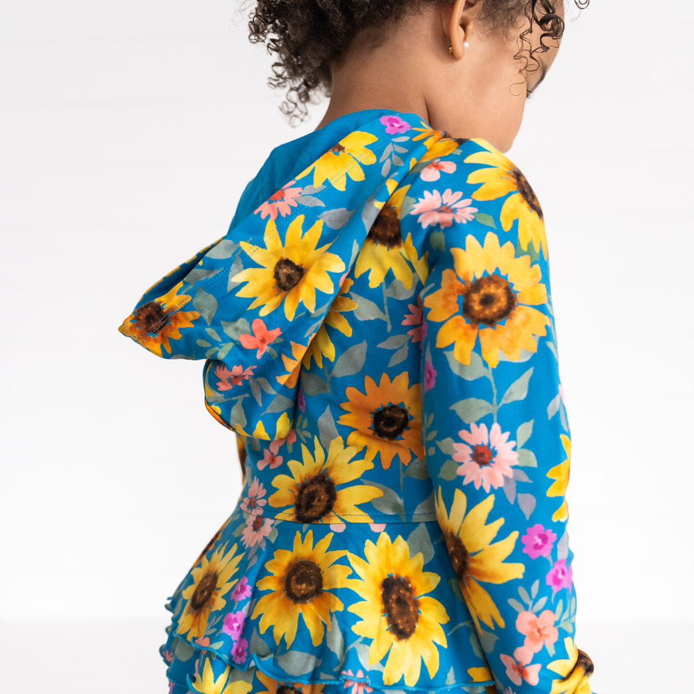 Close up back view image of a child wearing a Sunflower Fields Peplum Hoodie