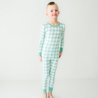 child posing wearing an Aqua Gingham two piece pajama set