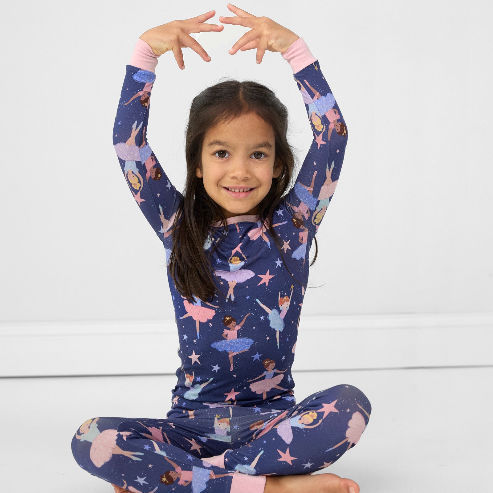 Image of a child sitting and posing wearing a Twilight Ballet two piece pj set
