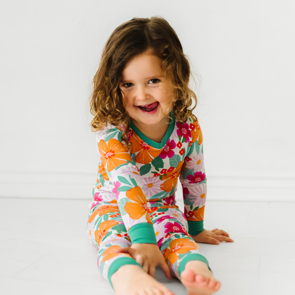 Child sitting wearing Beachy Blooms two piece pajama set