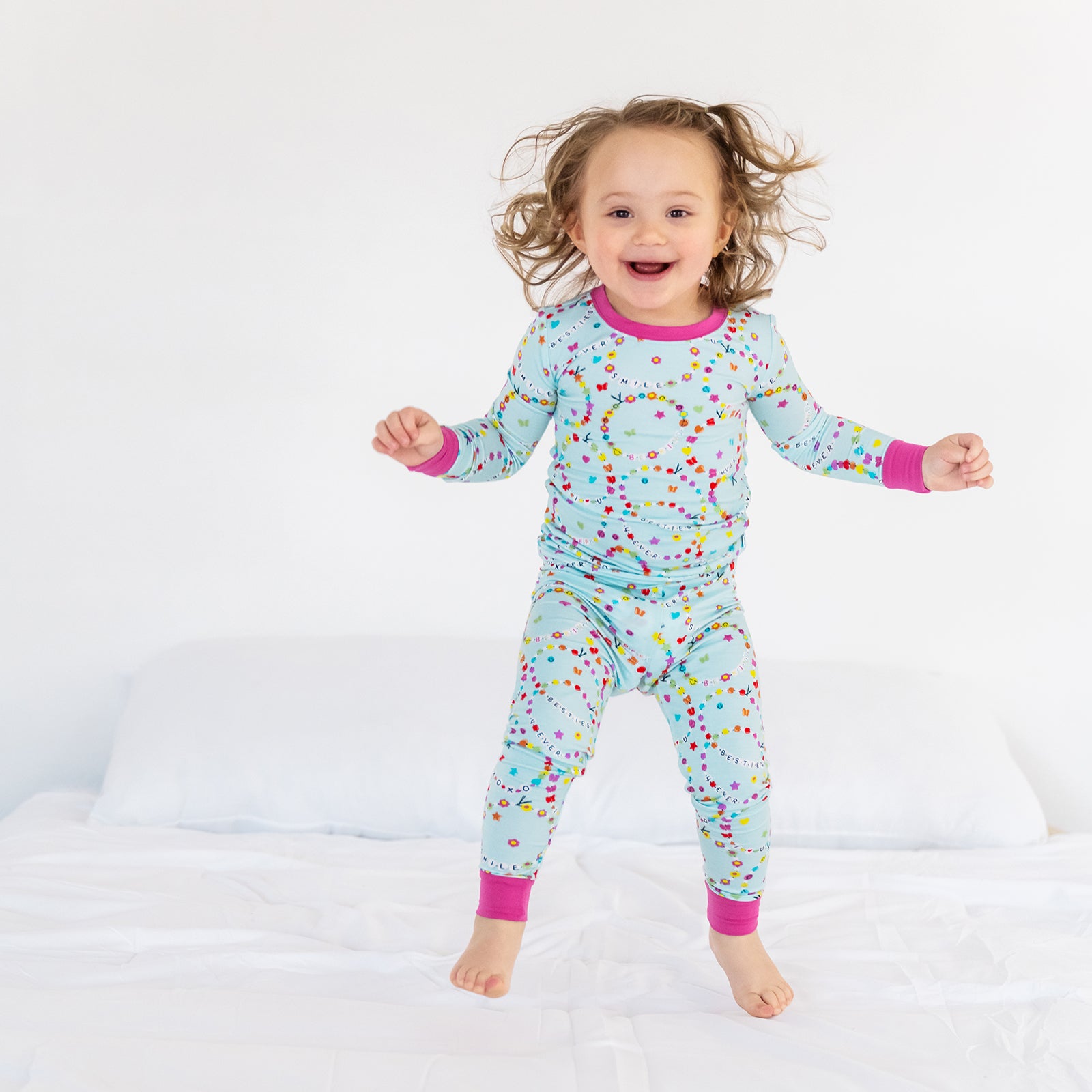 Image of a child jumping wearing the Friends Forever two piece pajama set