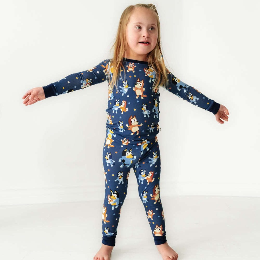 Child posing wearing a Bluey Dance Mode two piece pajama set