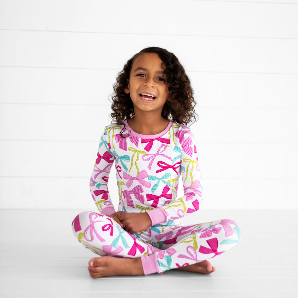 child sitting wearing a Ribbons and Bows two piece pj set