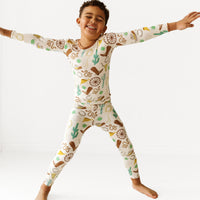 Child posing wearing a Caramel Ready to Rodeo two piece pajama set