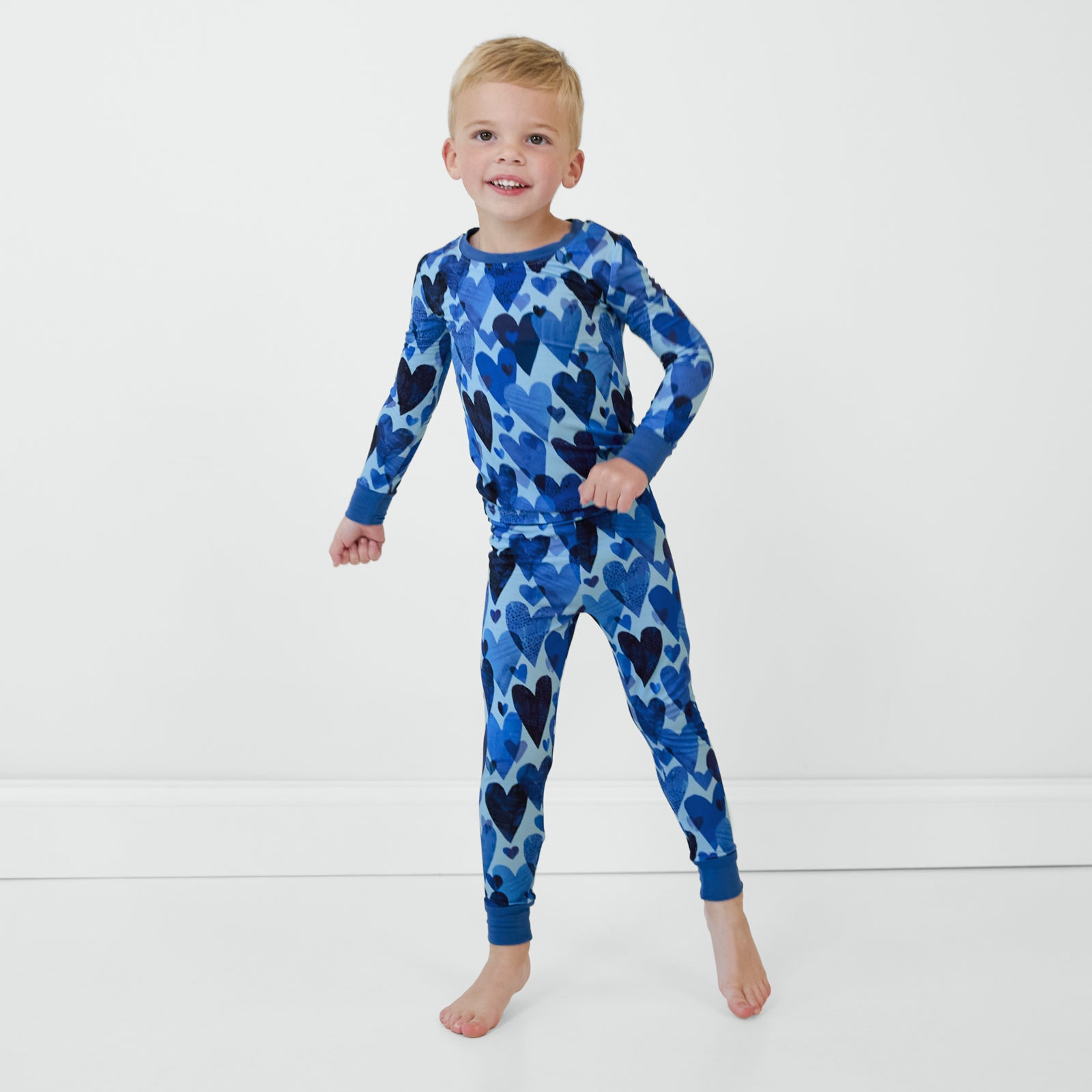 Boy wearing Blue Hearts & Crafts two-piece long sleeve and pants pajama set.