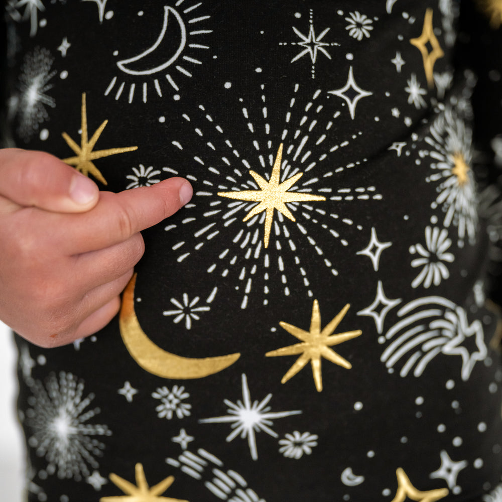 close up image of a child showing off the metalic details on a Celebration Stars two piece pj set