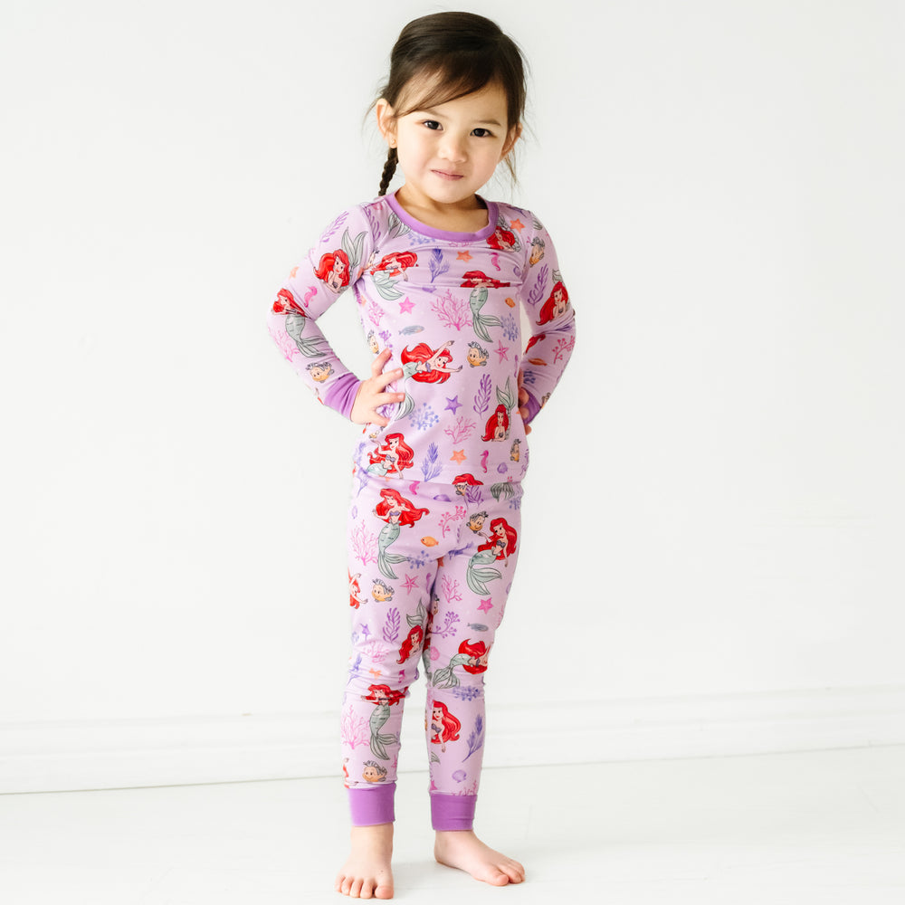 Child posing wearing a Disney Part of Her World two piece pajama set