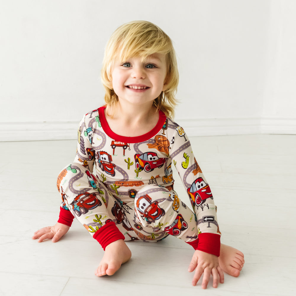 Child sitting wearing Radiator Springs two piece pajama set