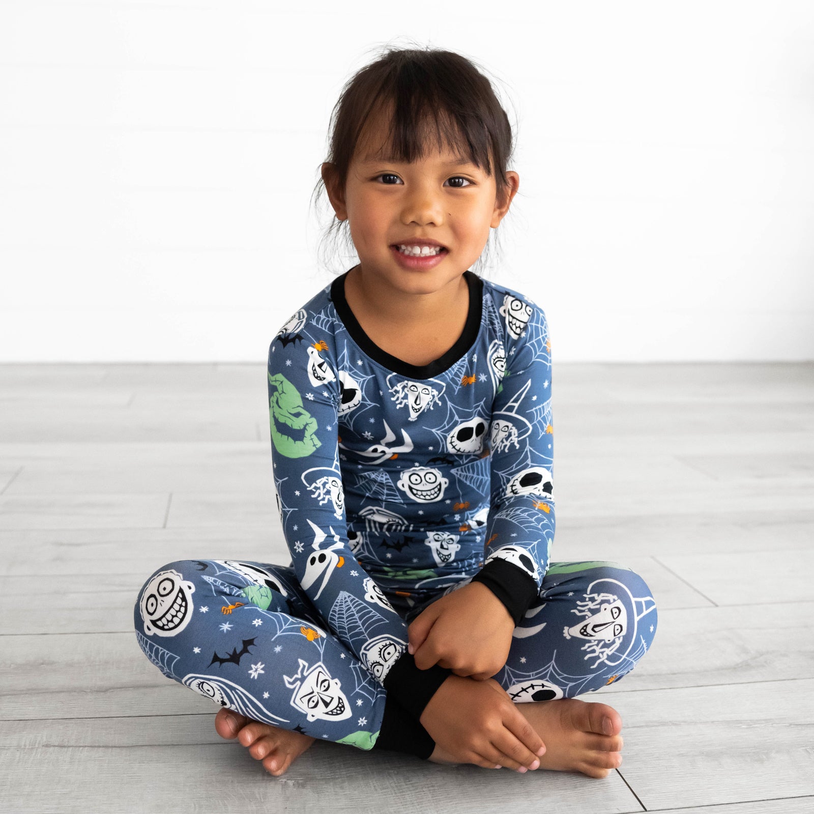 Child sitting while wearing the Disney Jack & Crew Two-Piece Pajama Set