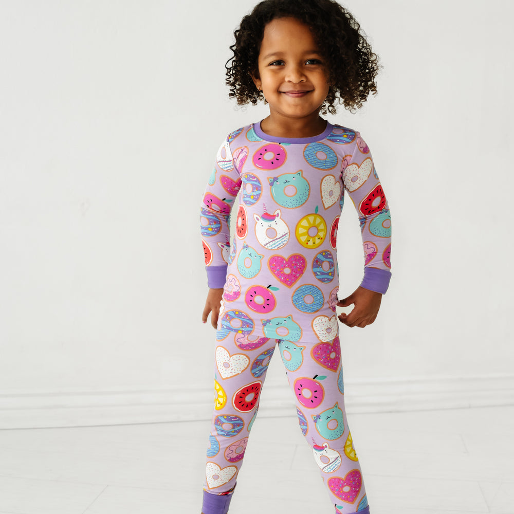 Click to see full screen - child posing wearing a Lavender Donut Dreams two piece pajama set