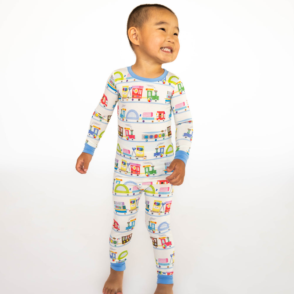 Child standing while wearing the Education Express Two-Piece Pajama Set