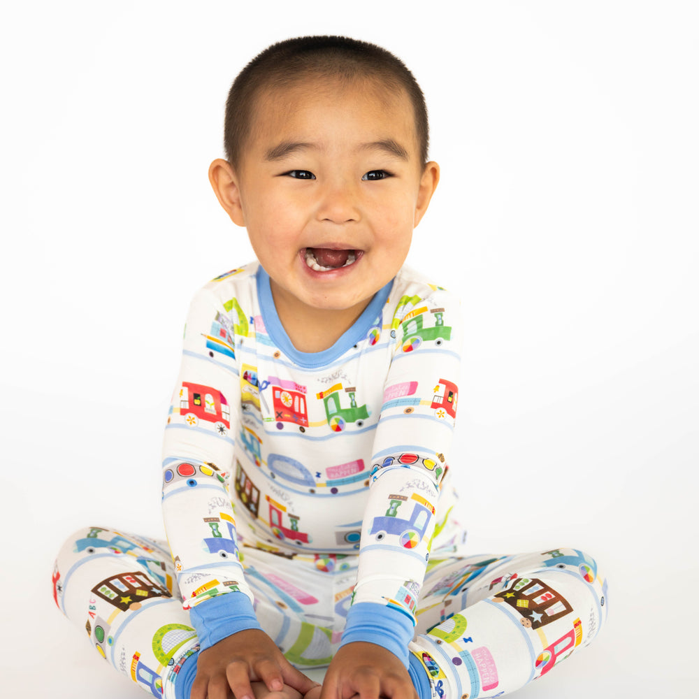 Child sitting while wearing the Education Express Two-Piece Pajama Set