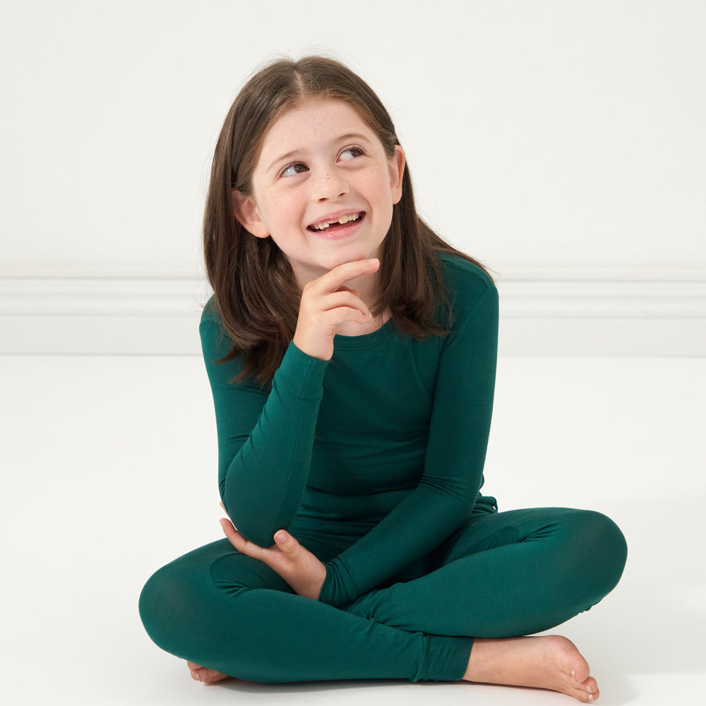 Girl is posing while sitting down wearing the Emerald Two-Piece Pajama Set