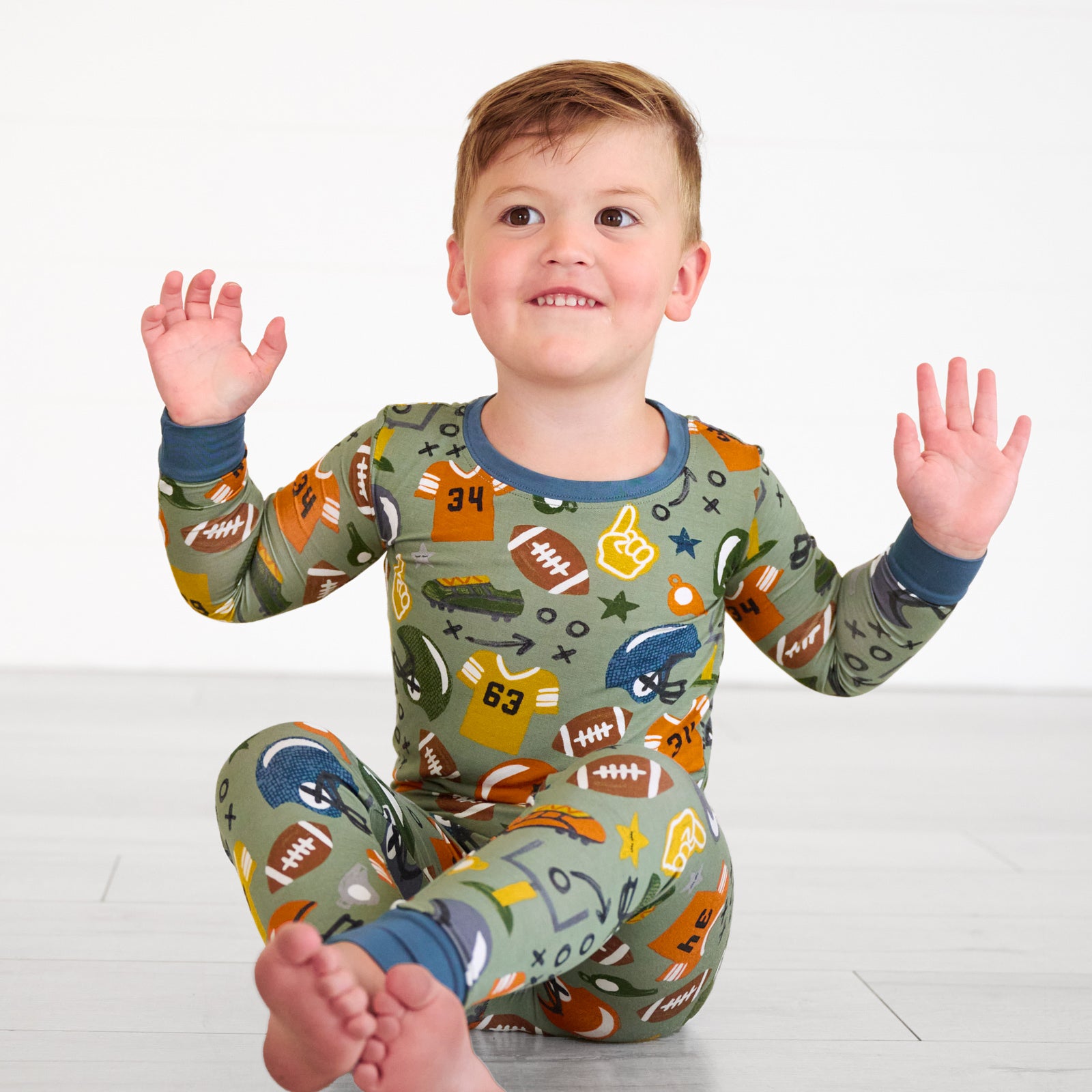 Boy sitting while in the touchdown-time-two-piece-pajama-set