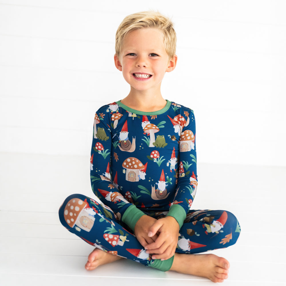 Smiling boy sitting while in the Forest Gnomes Two-Piece Pajama Set