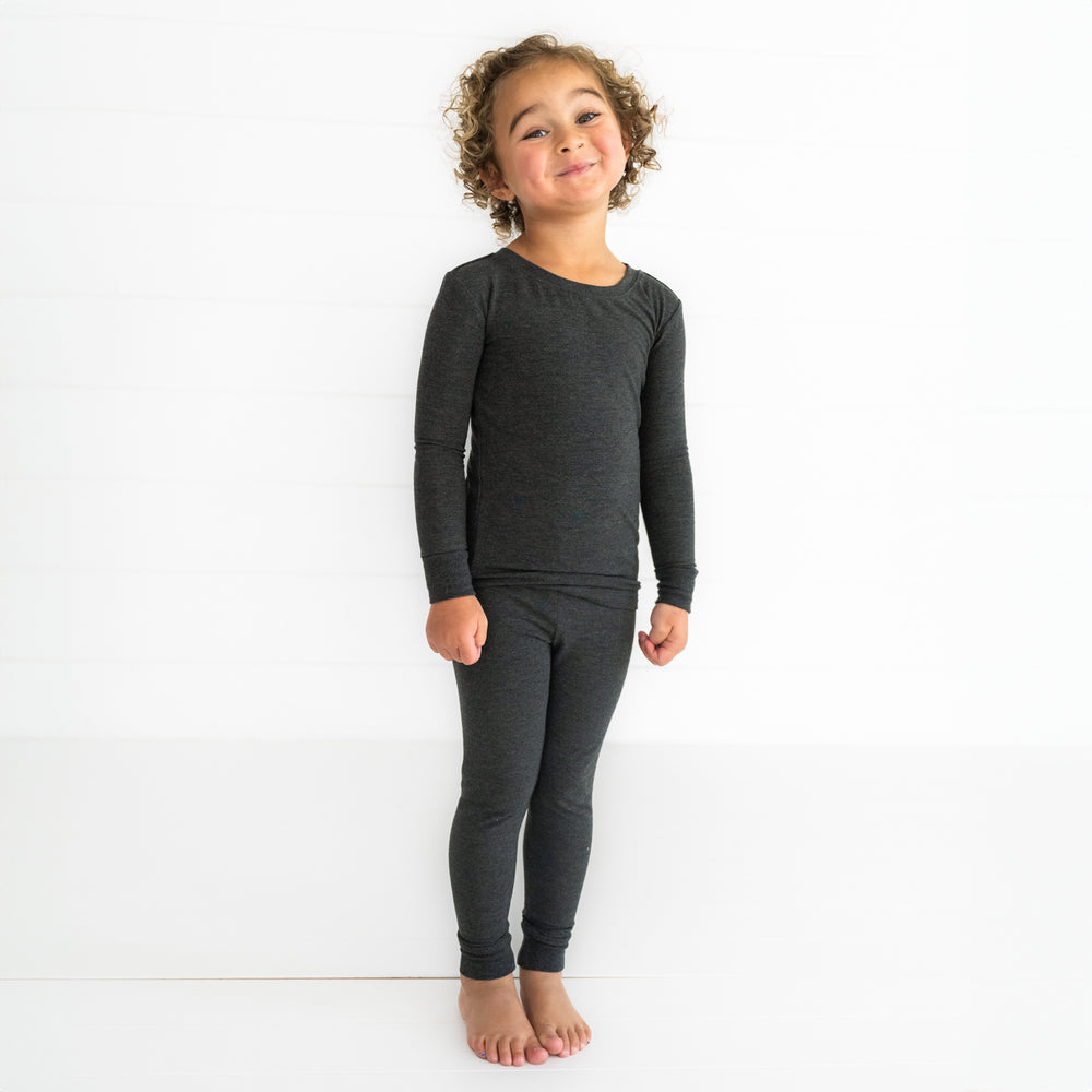 Child posing wearing a Cozy Heather Black two piece pj set