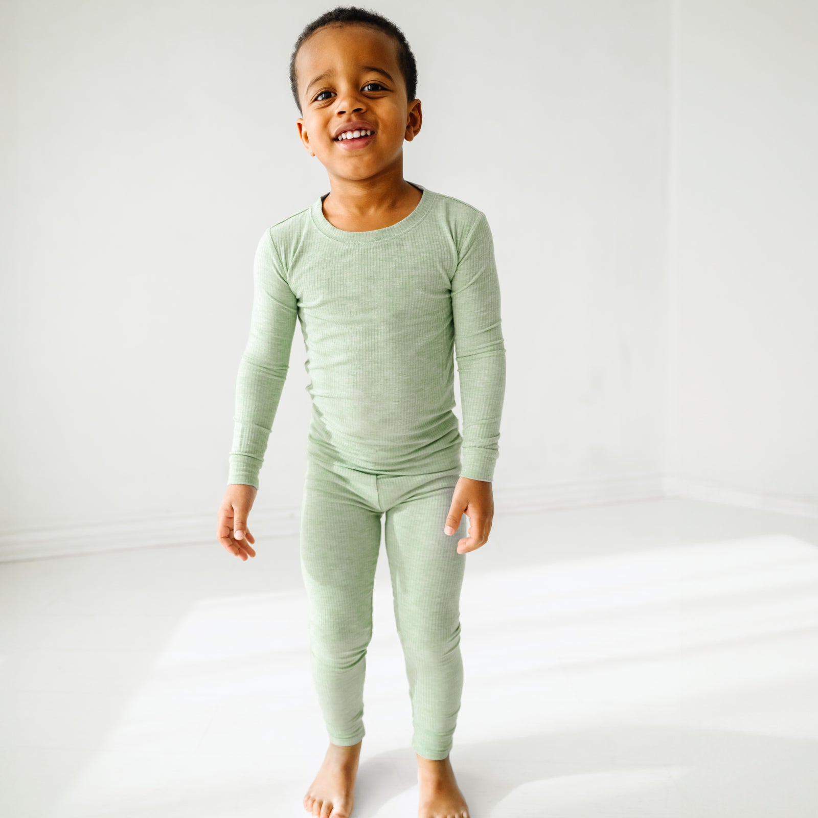 Child wearing a Heather Sage two piece pajama set