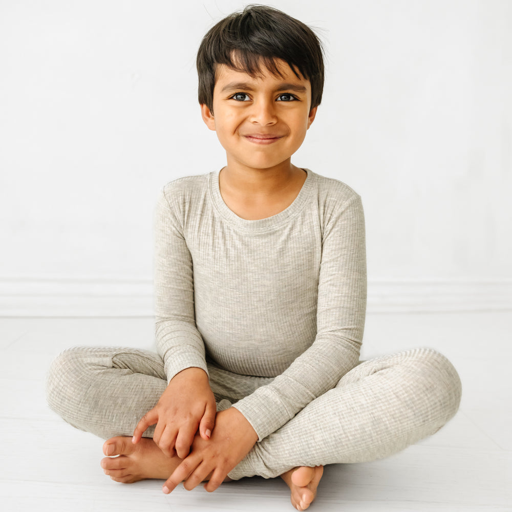 Click to see full screen - Child sitting wearing a Heather Stone Ribbed two piece pajama set