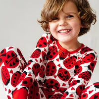 Close up image of a child wearing a Love Bug printed two-piece pajama set