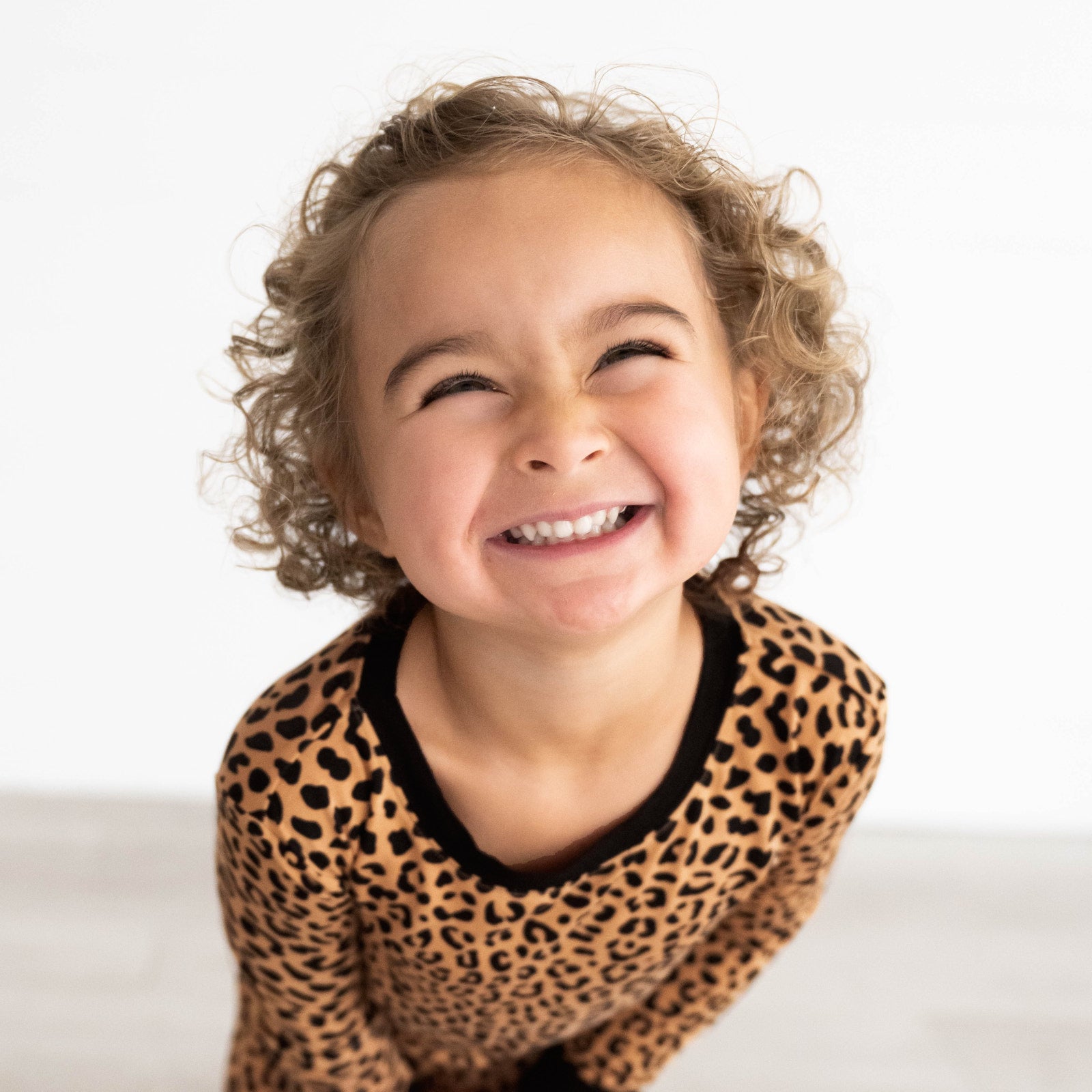 Close up image of girl smiling while wearing the Classic Leopard Two-Piece Pajama Set