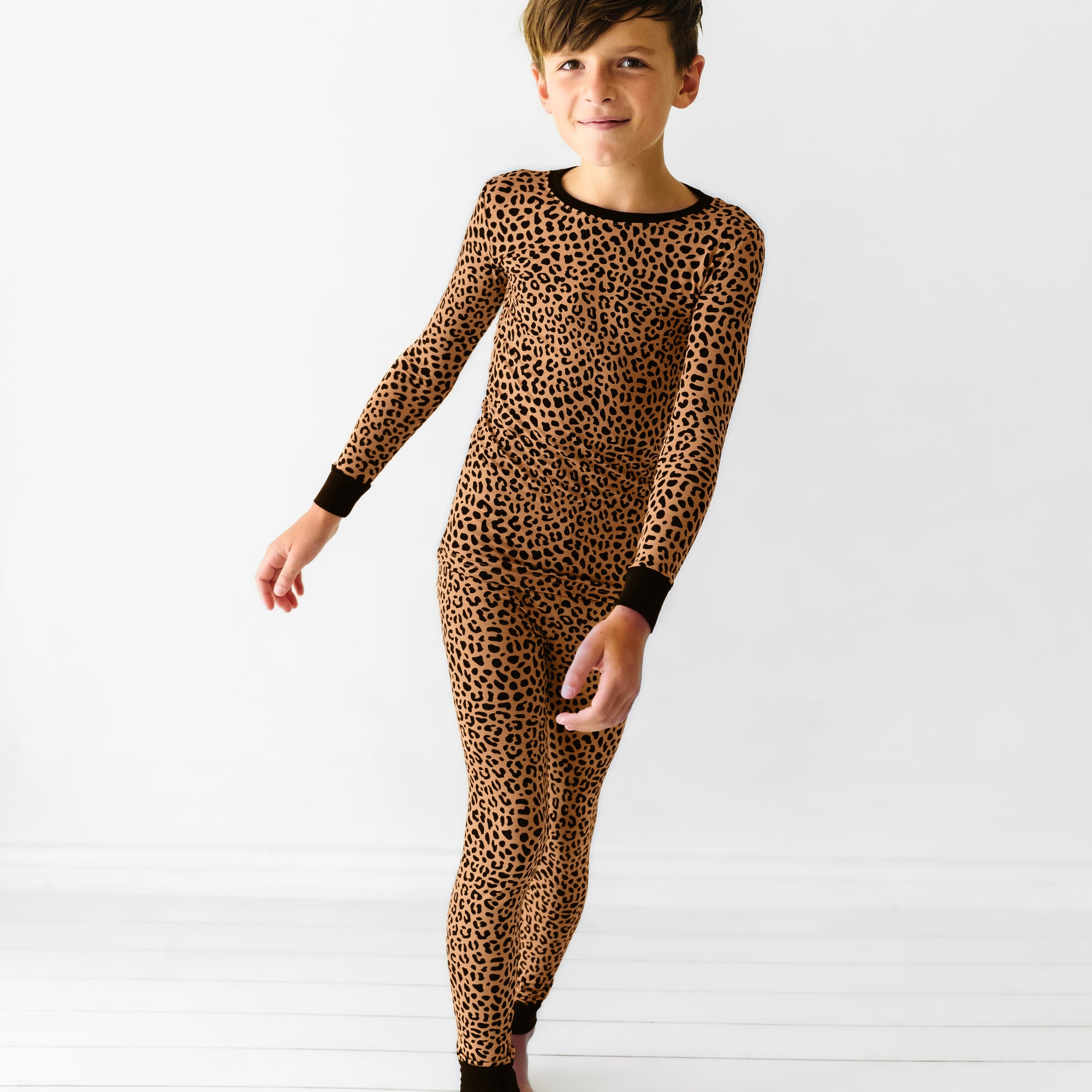 Child posing while wearing the Classic Leopard Two-Piece Pajama Set