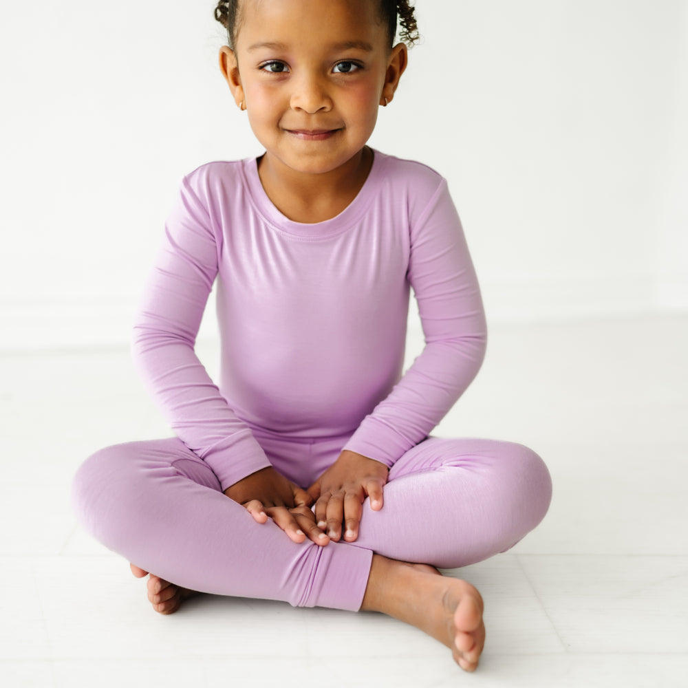 child sitting wearing a Light Orchid two piece pajama set