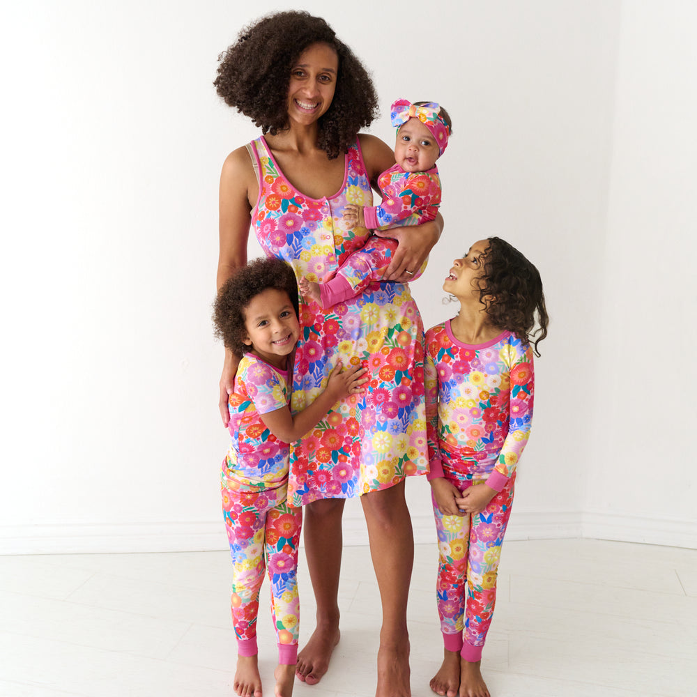 Family of four wearing matching Rainbow Blooms pajamas
