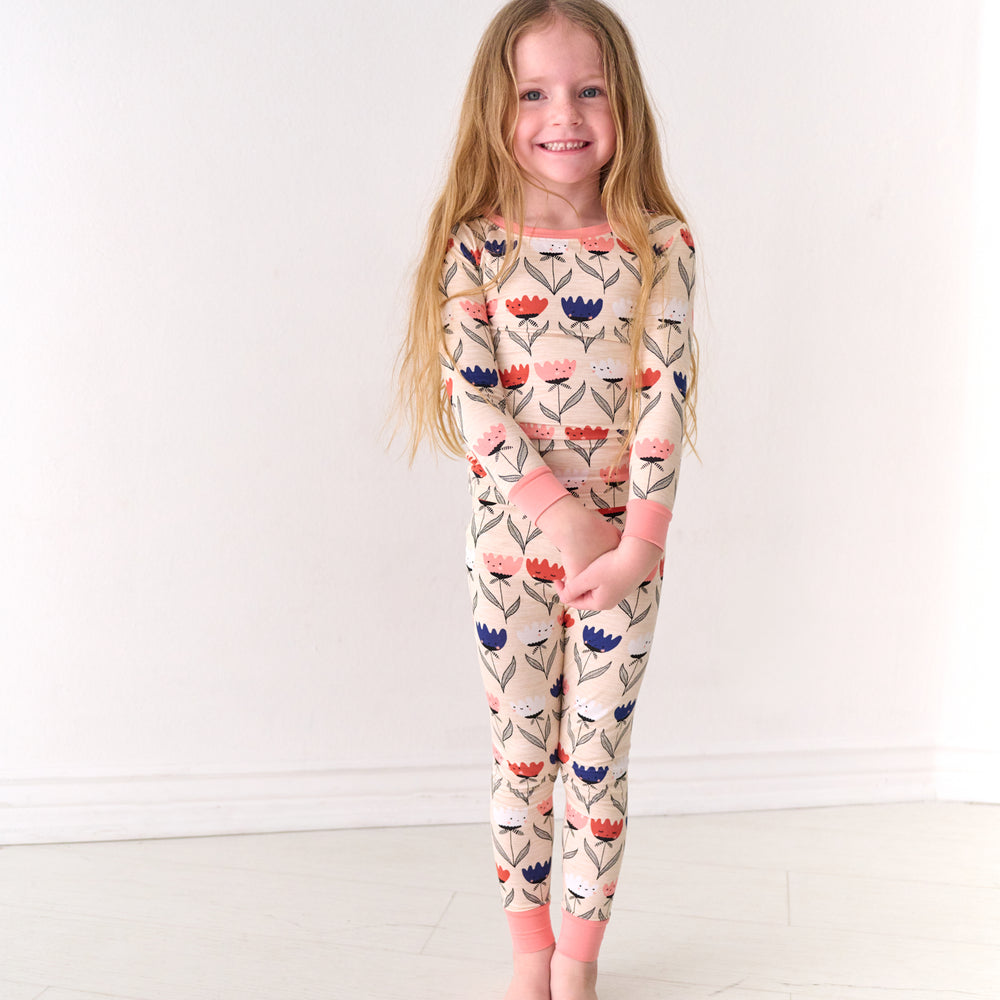Child holding her hands together wearing a Flower Friends two-piece pajama set