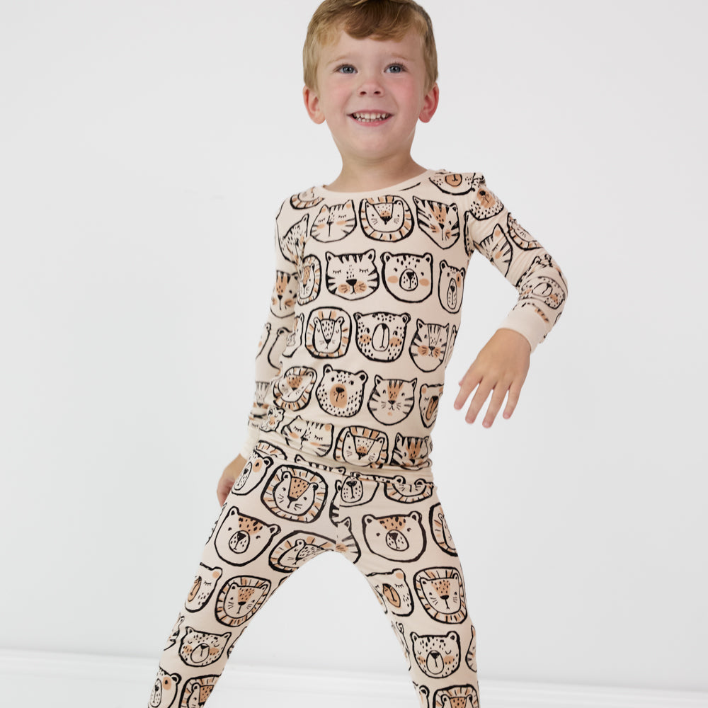 child posing wearing a Lions, Tigers, and Bears two piece pj set