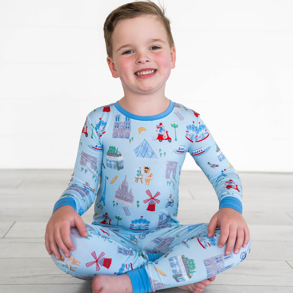 Boy sitting while wearing the Blue Weekend in Paris Two-Piece Pajama Set