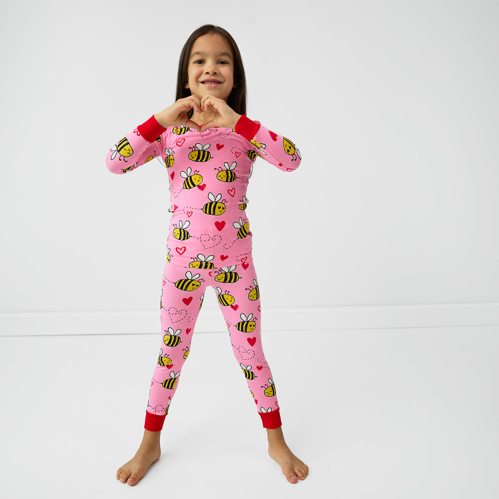 Image of a child posing wearing a Pink Bee Mine two piece pj set