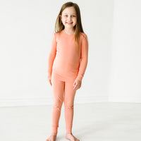 Child wearing a Peach two piece pajama set
